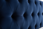 Close-up of navy blue velvet fabric on divan bed panel headboard