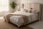 Cream wingback divan bed styled with white linen and soft cushions, bright bedroom