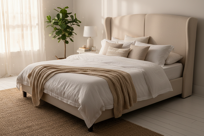 Cream wingback divan bed styled with white linen and soft cushions, bright bedroom