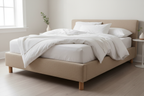 Linen ottoman bed side angle showing wooden legs and upholstered frame