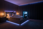 Couple watching TV in bed with LED ambient glow, grey TV bed lifestyle shot
